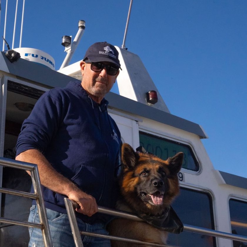 CAC18D23-0926-4006-87BF-A25A9D9DD3DE a man holding a dog